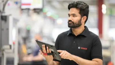 A worker monitors machines in a factory hall and optimizes processes with a tablet.