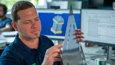 Bosch Linz employee inspecting metal component for PEM electrolysis stack design