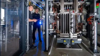 Two men standing at the Hybrion Stack Test Station.