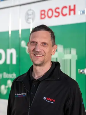 Portrait of Ralph Troppmann in front of the electrolysis container, which he operates.